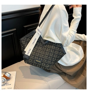 Detailed close-up of checkered tweed tote bag with chic wide shoulder strap and leather trim