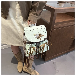 Detail of checkered backpack with mint green star pattern and sweet ribbon bow detail