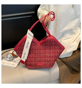 Detail of red tweed woven tote bag with gold thread accents and fashion brand label