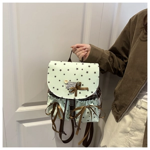 Detail of mint green star-patterned canvas backpack with wooden button and silk bow