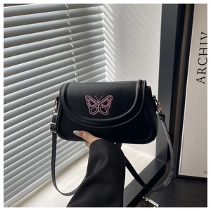 Detailansicht der rosa Schmetterlingsstickerei auf schwarzer Ledertasche mit Goldakzenten