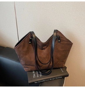 Detail of dark brown suede tote bag with diamond stitching and silver twist lock