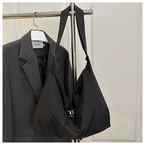 Detail view of the durable double metal zipper on a black nylon crescent tote bag