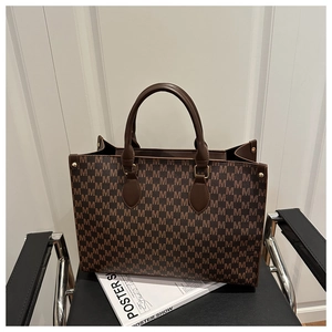 Detail of vintage M-pattern jacquard tote with premium leather handles and metal rivets
