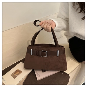 Detail of dark brown suede tote bag featuring retro leather belt and silver buckle