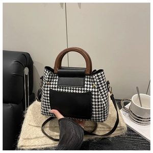Détail du sac pied-de-poule avec poignée en bois vintage et poche en cuir noir