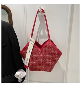 Detail of red tweed bucket bag with V-cut opening and fashion logo lettering