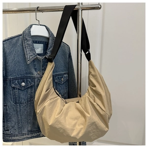 Détail du sac croissant kaki grande capacité avec large bandoulière noire et tissu texturé