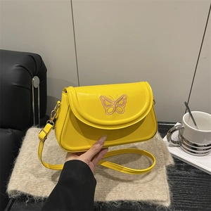 Yellow half-moon crossbody bag with purple embroidered butterfly and adjustable strap