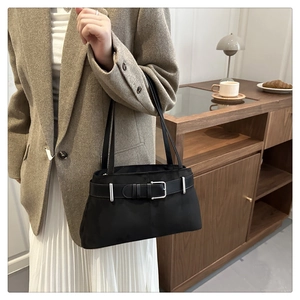 Detail of black tote bag with vintage belt buckle design and silver hardware