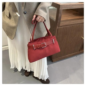 Detail view of large burgundy suede tote bag with leather strap and metal buckle