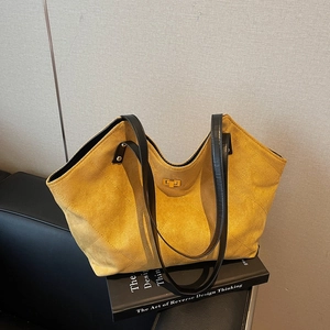 Quilted yellow suede tote bag with black leather straps and golden twist-lock closure