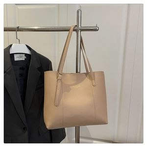 Detail of light beige faux leather tote with gold fashion lettering and adjustable strap