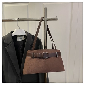 Detail of vintage brown suede tote bag featuring decorative leather belt and silver buckle
