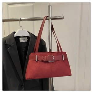 Close-up of red suede tote bag featuring a decorative belt buckle and slender shoulder straps