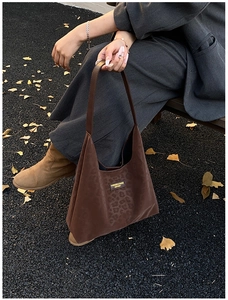 Detail of a dark brown leopard print tote bag in matte suede texture for commuting