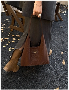 Detail of a dark brown leopard print tote bag with a leather fashion tag on the front