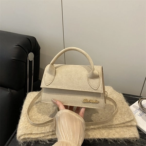 French style beige suede crossbody bag with top handle and gold cursive logo detail