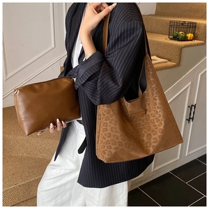 Brown leopard embossed tote bag set shown with striped blazer and matching small pouch