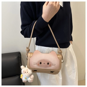 Detail of cute khaki cat crossbody bag with cartoon face design and plush rabbit charm