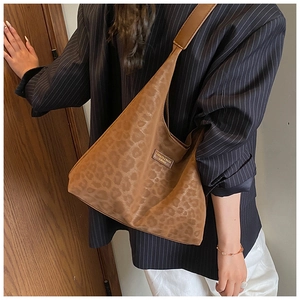 Detail of leopard print tote bag with brown leather patch on a model for casual commuting