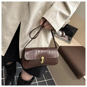 Vue détaillée du sac à main marron foncé à motif crocodile avec fermoir doré élégant