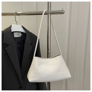 Dettaglio della trama intrecciata bianca su una borsa a tracolla dal design minimalista