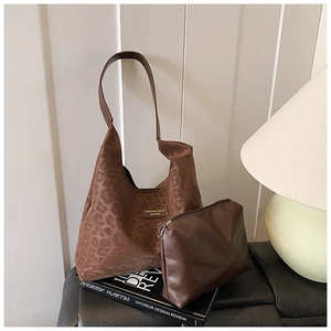 Detail of leopard print suede tote bag with matching inner pouch on a white background