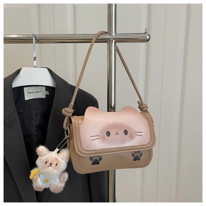 Detailed view of khaki and pink cartoon cat shoulder bag with white bear charm pendant