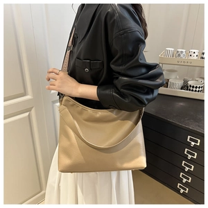 Détail du sac hobo kaki avec bandoulière à motifs et poignée en similicuir
