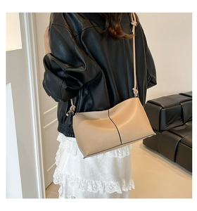 Detail of beige leather shoulder bag with decorative knotted strap and vertical stitching