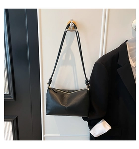 Detail of black pebbled leather texture and elegant knotted shoulder strap design