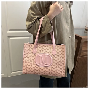 Close-up of pink tote bag with M-letter monogram and elegant embossed logo detail
