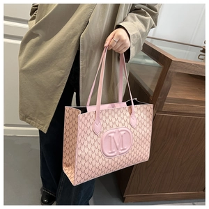 Detailed view of pink tote bag featuring embossed M monogram and logo texture