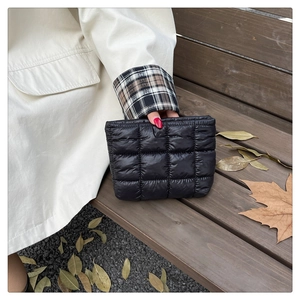 Close-up of black quilted nylon handbag texture with autumn aesthetic background