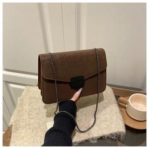 Détail du sac à bandoulière léopard montrant la texture mate et le fermoir en métal