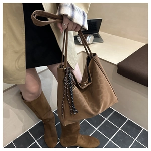 Close-up of brown suede tote bag with woven rope detail for autumn daily commute