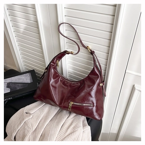 Détail du sac hobo bordeaux en cuir ciré rétro avec fermeture éclair dorée et boucle