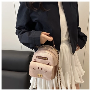 Detailed close-up of a pink mini backpack with cat ear accents and chain strap