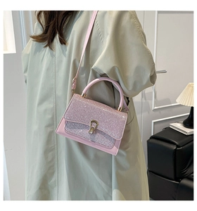 Vue détaillée du sac à bandoulière rose avec rabat pailleté et boucle métallique en U dorée