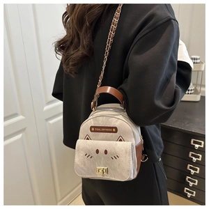 Detail of canvas mini backpack featuring cat ears design and golden twist lock closure