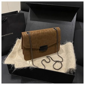 Détail du sac bandoulière à motif léopard avec chaîne métallique et texture mate