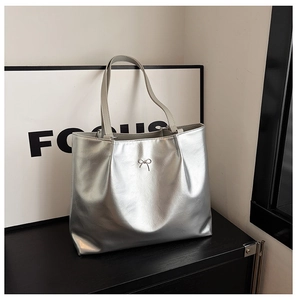 Close-up of metallic silver tote bag with delicate silver bow detail and focal texture