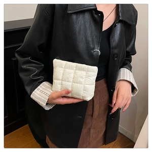 Detail of white quilted puffy handbag showing soft texture and compact rectangular design