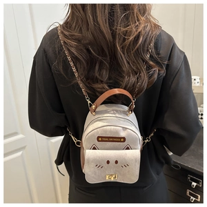Detail of gray and brown mini backpack with cat-ear design and metal chain strap