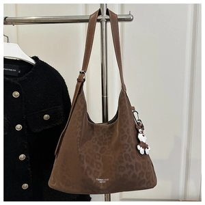 Detail view of large leopard print hobo bag with adjustable strap and bear pendant