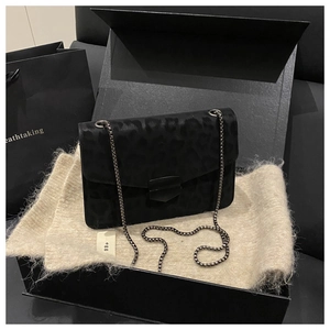 Détail du sac à chaîne léopard noir avec fermoir métallique dans son coffret cadeau