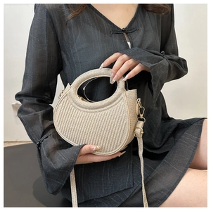 Detail of champagne gold handbag with textured pleats and circular handle