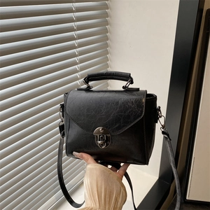 Schwarze Retro-Umhängetasche mit Vintage-Metallschnalle und strukturierter Lederoptik