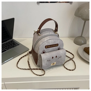 Close-up of cat-themed grey mini backpack with gold hardware and chain strap details